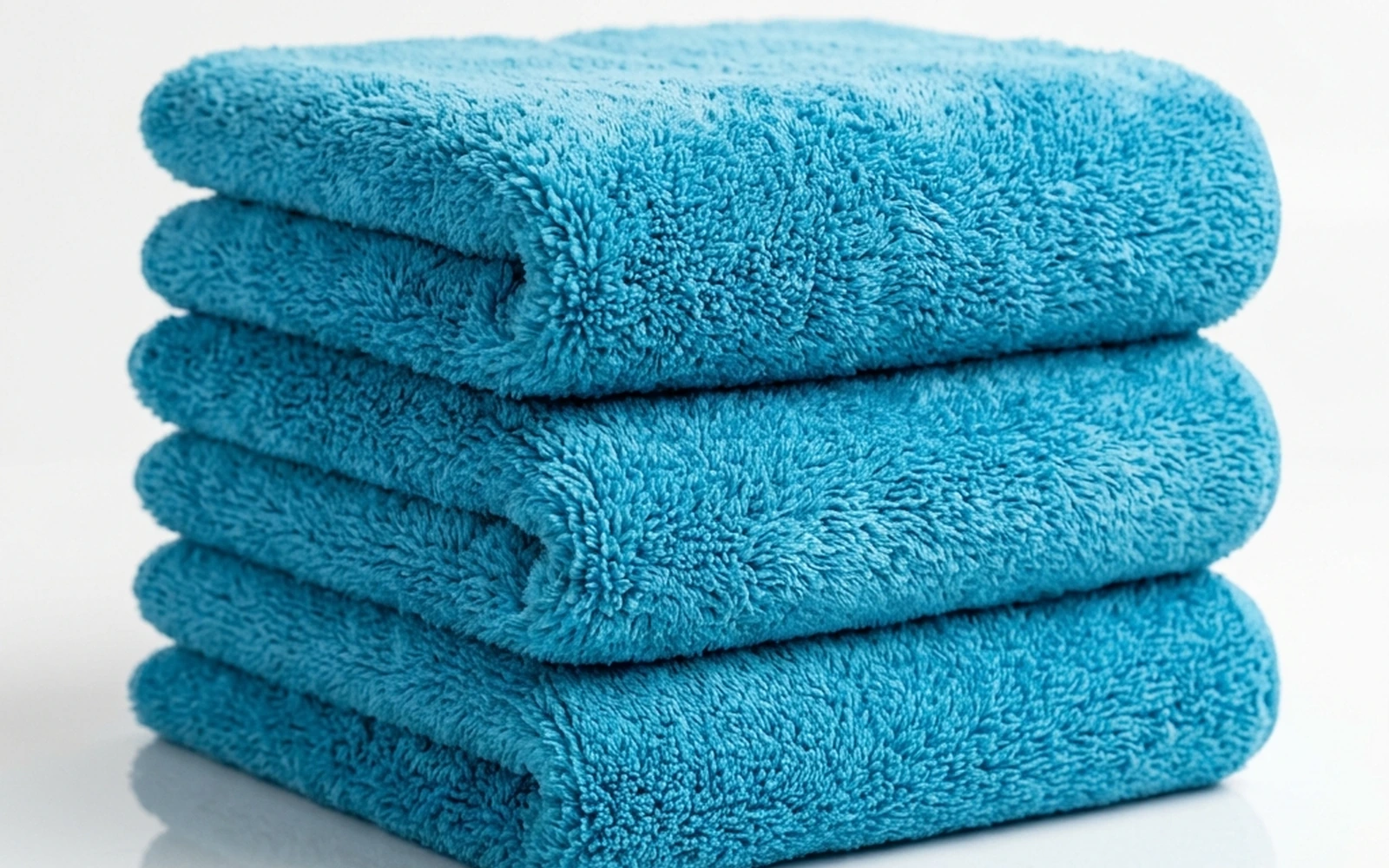 Microfiber detailing towels drying on low-heat delicate cycle in dryer
